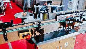 Automatic labeling machine for labeling glass medicine bottles