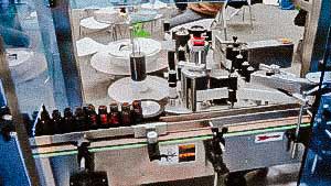 Automatic labeling machine for labelling labels on glass bottles