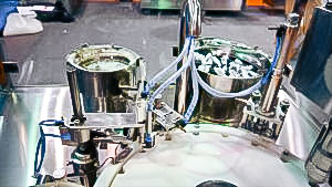 Automatic equipment for bottling and capping plastic bottles with spray nozzle