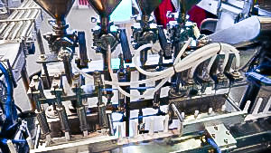 Automatic equipment for filling and capping plastic syringes