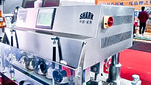 Automatic equipment for screwing plastic caps on plastic bottles