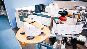 Automatic labeling equipment for sticking labels on both sides of flat bottles