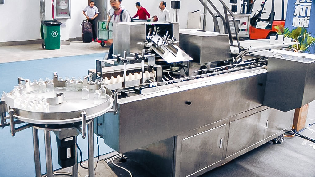 Automatic bottle packing equipment in cardboard boxes in pharmaceutical
