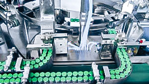 Automatic packaging equipment penicillin vials in cardboard boxes in pharmaceutical production